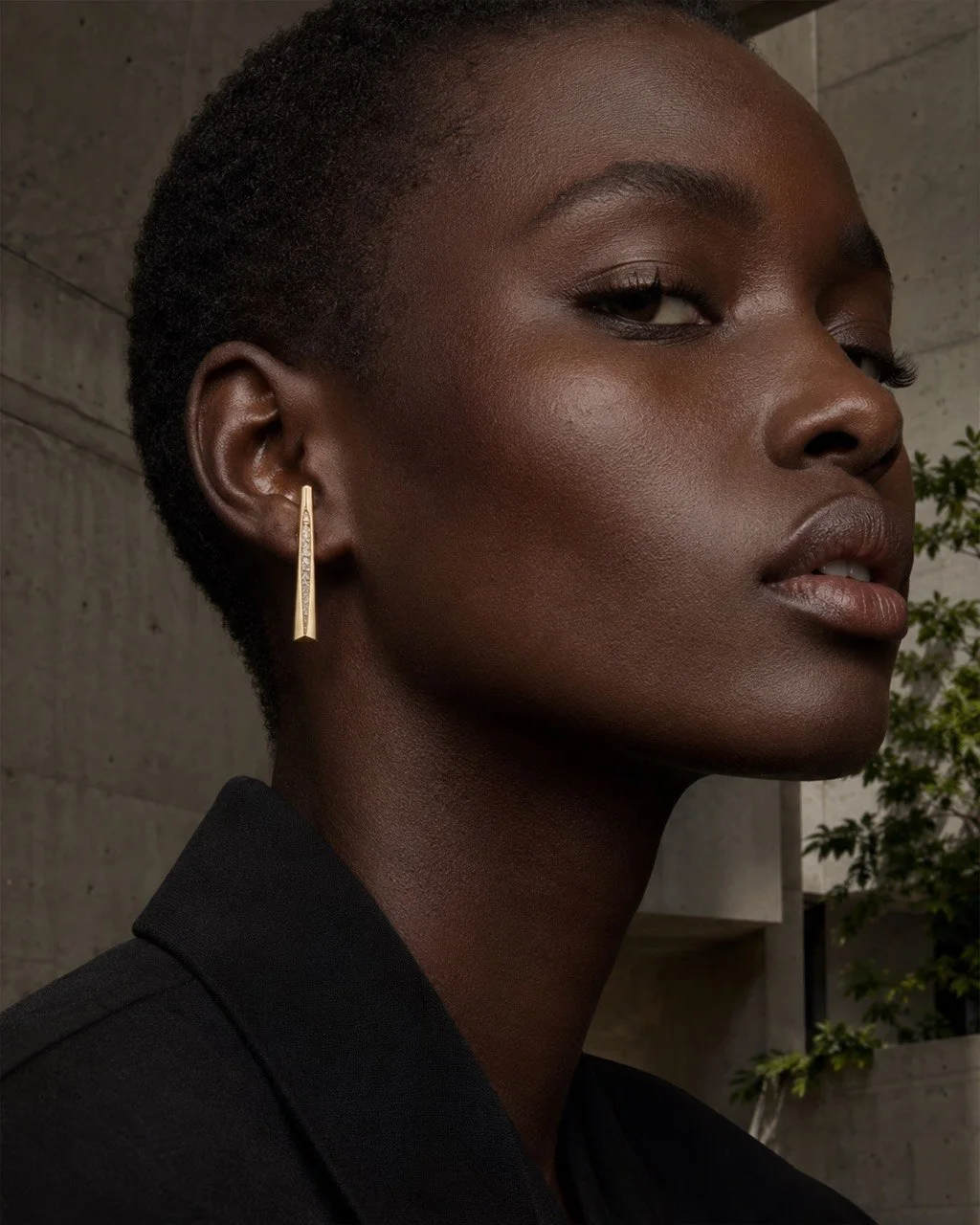 Model wearing a sculptural gold earring